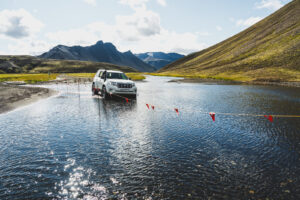 Auto 4×4 při průjezdu značeným říčním brodem v islandském vnitrozemí