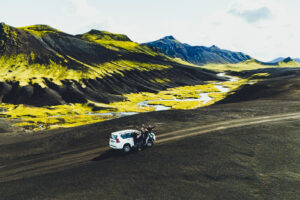Auto 4×4 a účastníci expedice v rozlehlé vulkanické krajině Islandu