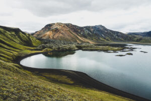 Jezero obklopené zelenými a barevnými horami islandského vnitrozemí - Landmannalaugar