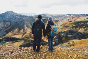 Dva účastníci expedice na vyhlídce nad barevnými horami islandského vnitrozemí - Landmannalaugar