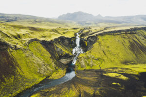 Vodopád Ófærufoss a řeka v hlubokém zeleném údolí islandského vnitrozemí